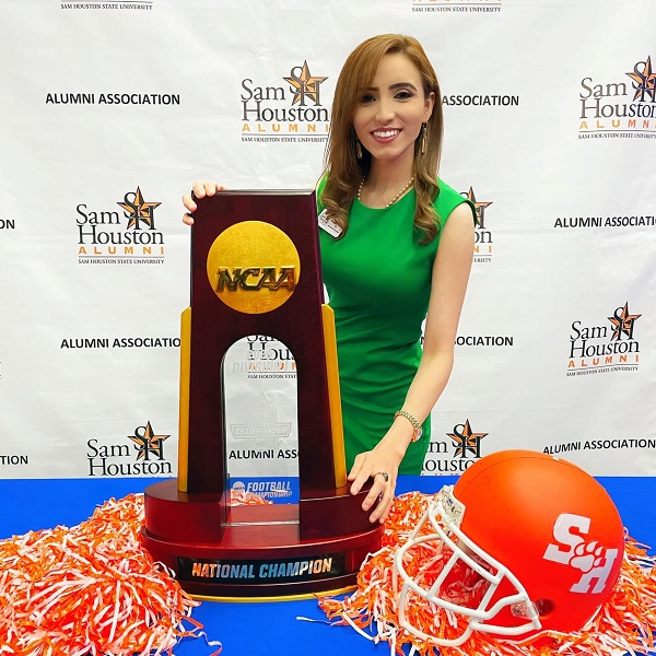 Jessica Rodriguez-Wahlquist holding championship football trophy. 